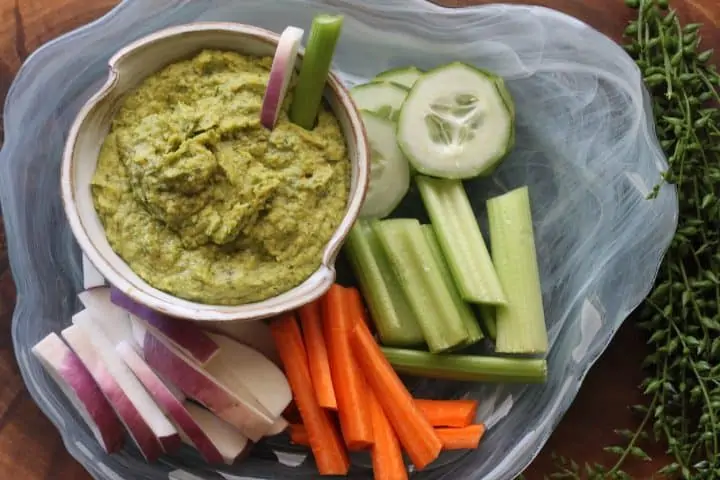 bowl of bean dip with carrots, celery, cucumbers
