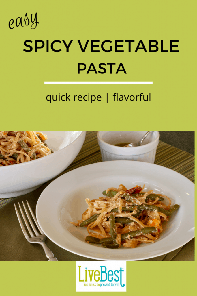 bowl of spicy vegetable pasta with ramekin of chile oil nearby