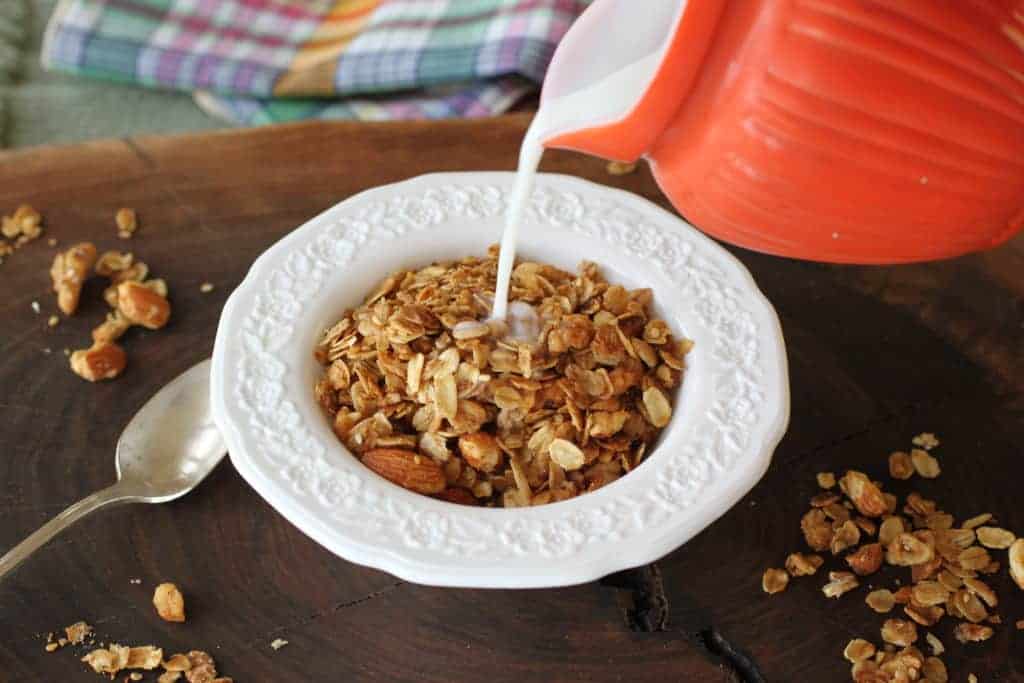 Ginger Orange Granola in a bowl with milk being poured on