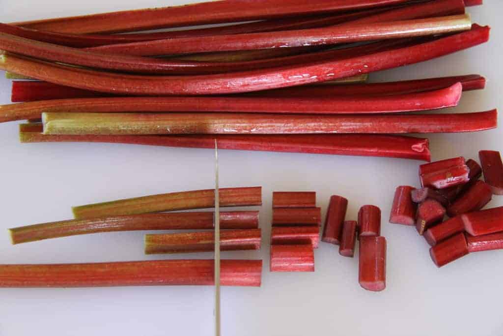 cut pieces and stalks of rhubarb on cutting board