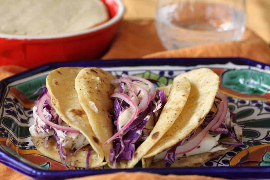 3 Fish tacos, pickled onions and chipotle crema on a plate