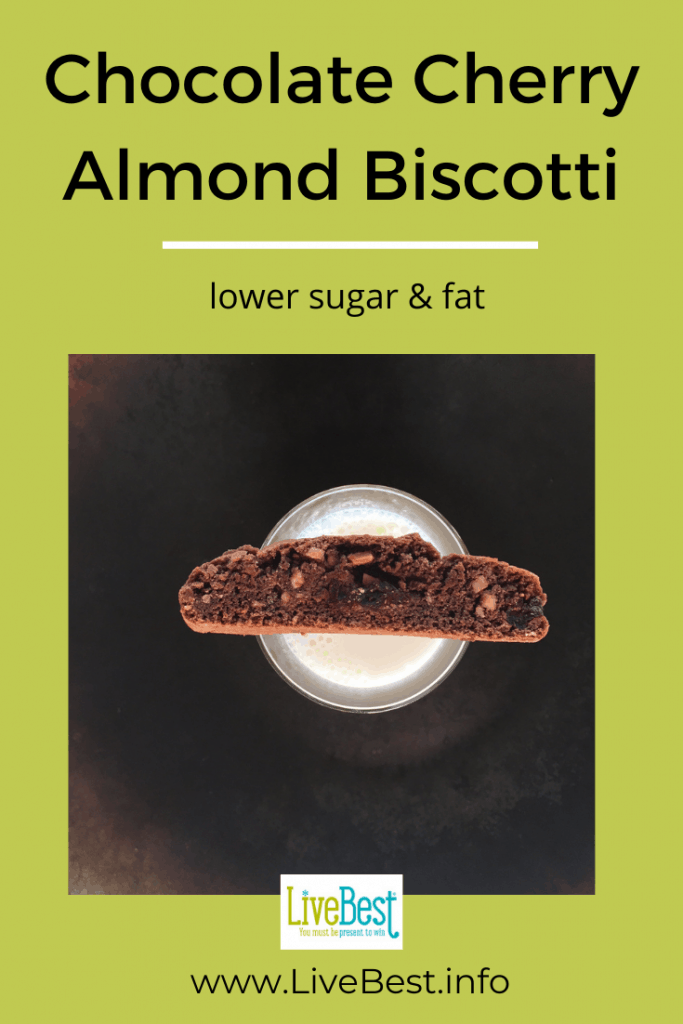 one chocolate cherry biscotti perched on a glass of milk