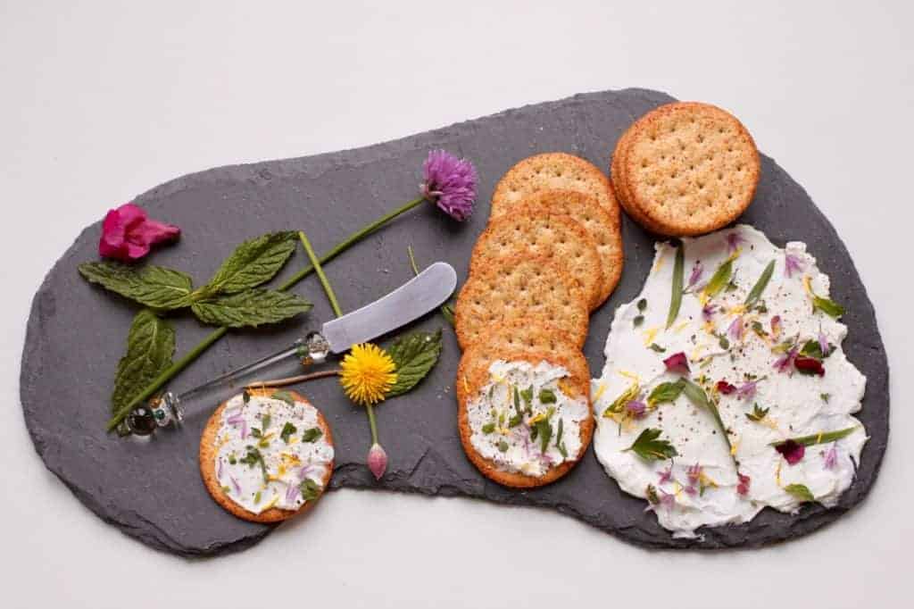 Herb and flowers on thick yogurt  with crackers