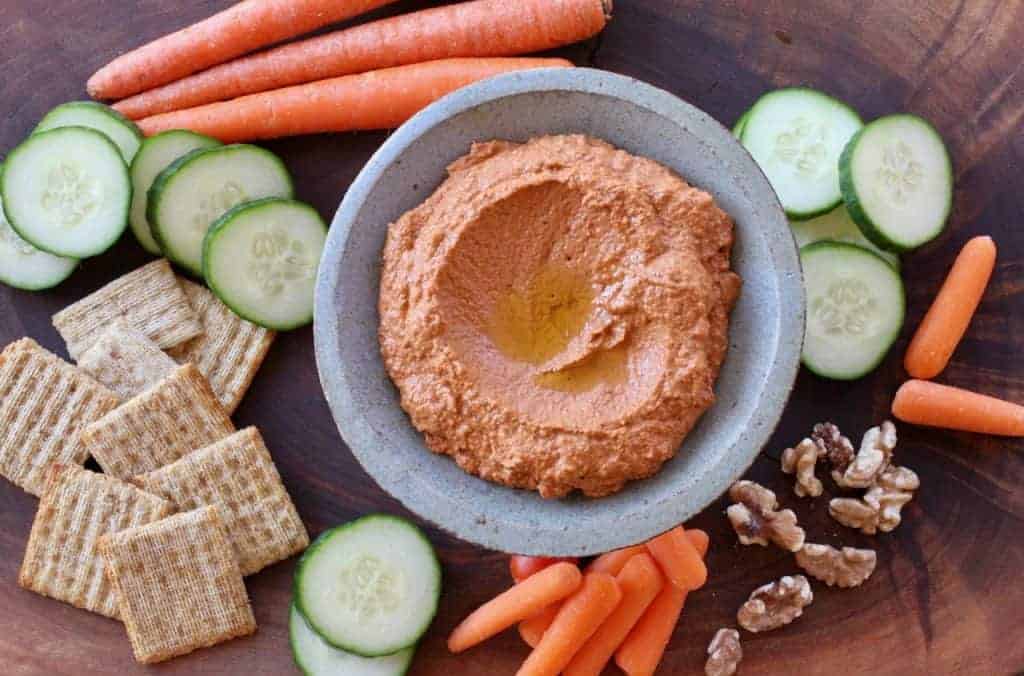 Roasted Red Pepper Dip surrounded by crackers and vegetables