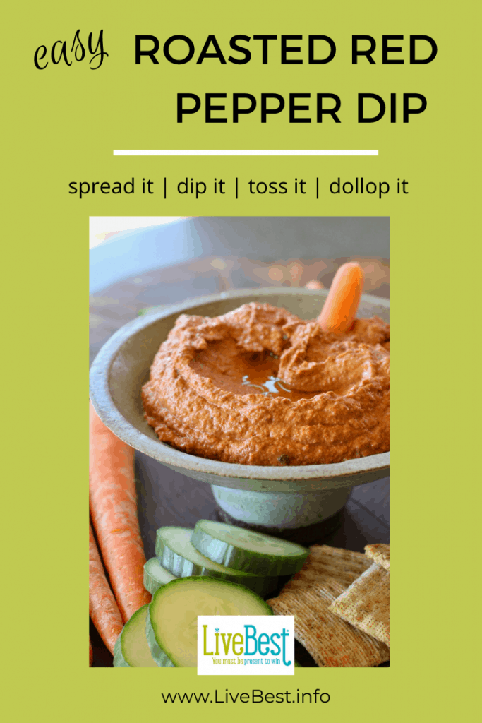 bowl of red pepper dip with fresh vegetables surrounding the bowl