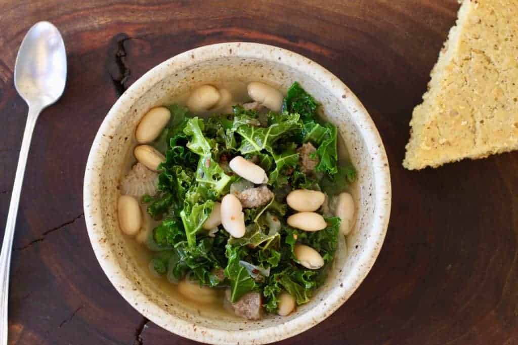 bowl of Kale Turkey White Bean Soup and cornbread wedge