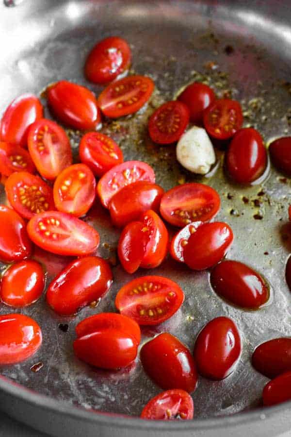 Tomatoes in skillet with garlic and olive oil 
