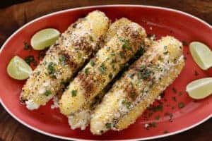 platter of Grilled Mexican Street Corn with lime wedges 