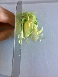 Image of knife thinly slicing Brussels sprouts