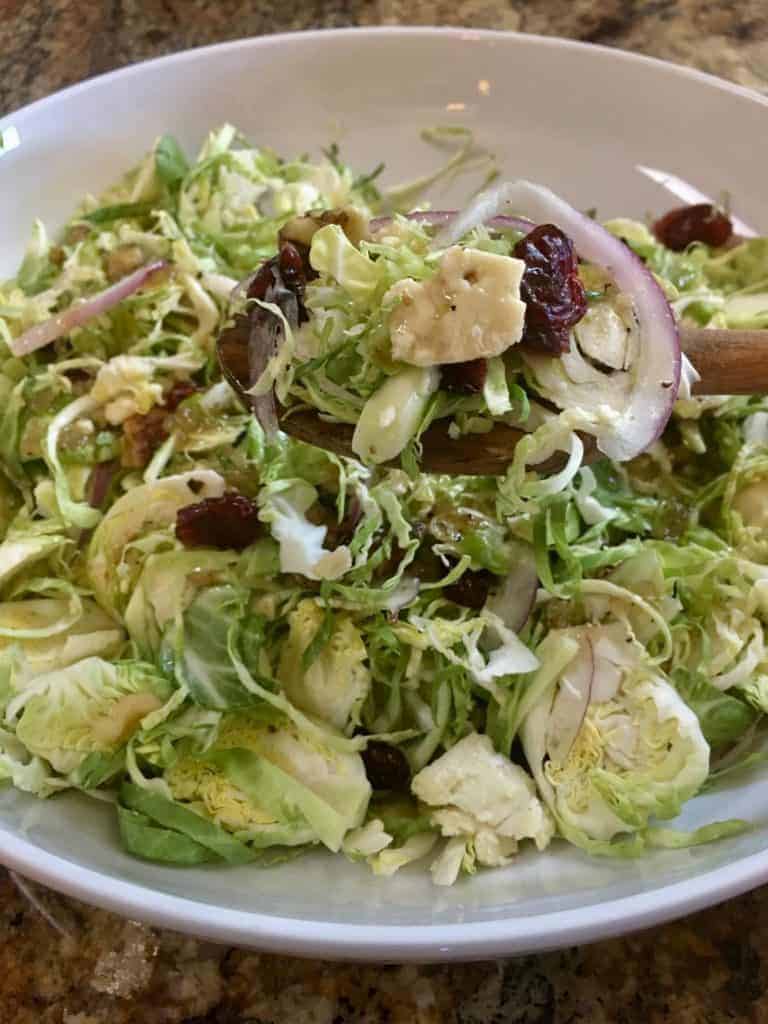bowl of shaved brussels sprout salad with cranberries and cheese