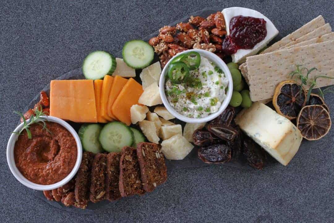 cheese board with dips, crackers and vegetables