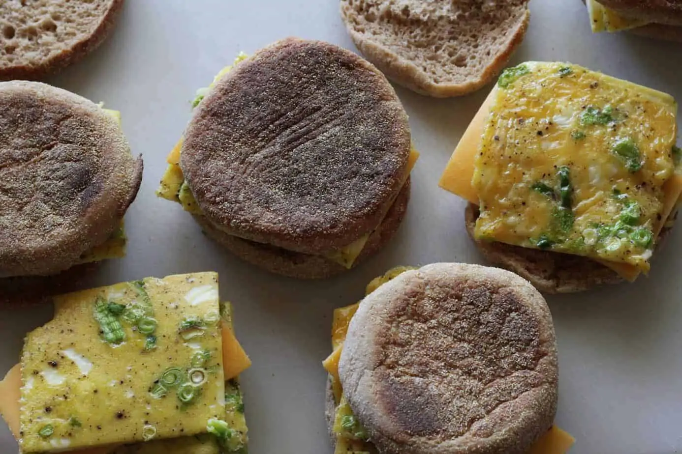 english muffins with egg and cheese on a baking sheet