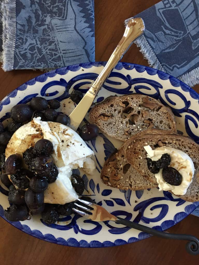 roasted purple grapes on burrata cheese on Mexican plate