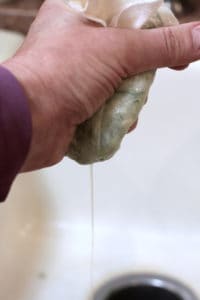 squeezing the juice from a cucumber in a paper towel 