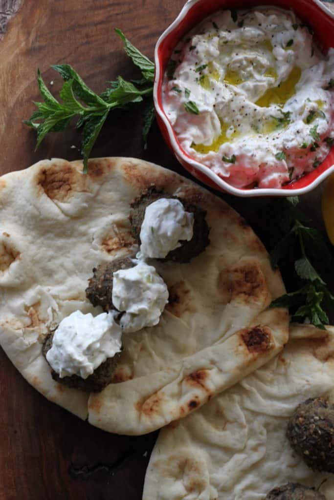 Greek tzatziki sauce dollops on meatballs and pita