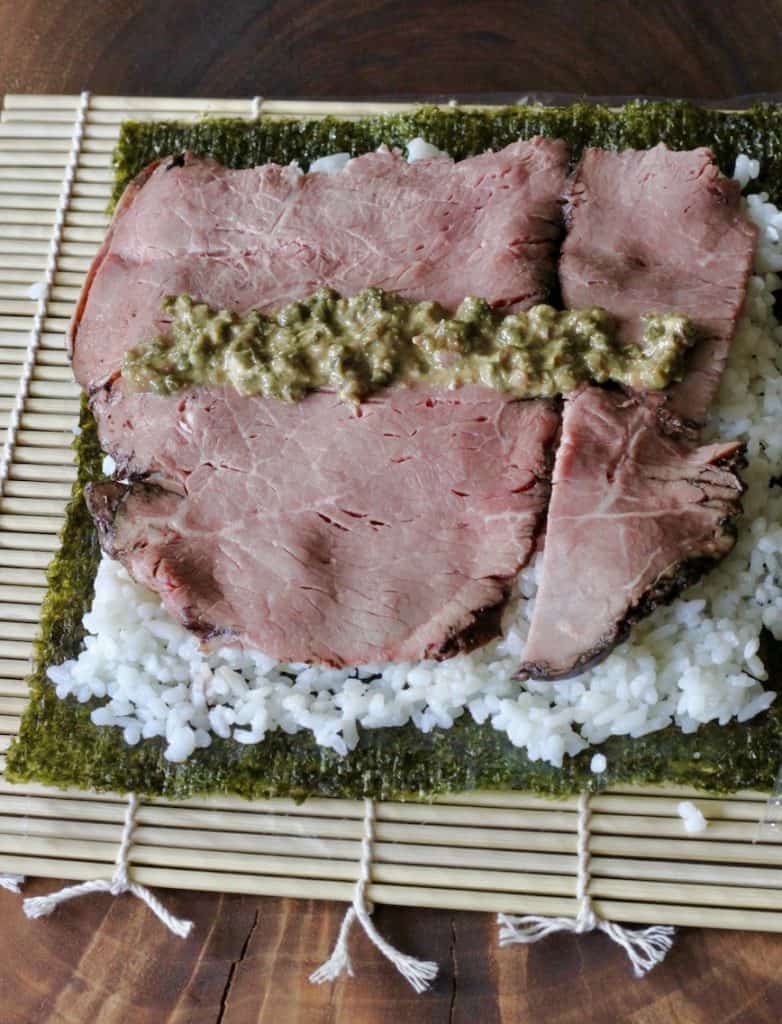 nori, rice, roast beef slices and mustard anchovy mixture ready to roll for sushi
