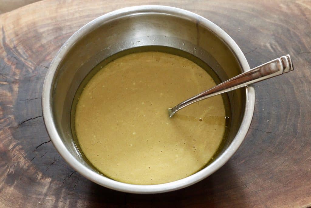 bowl of mixed eggs, yogurt and oil for zucchini bread