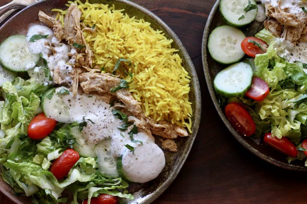 2 plates with chicken with rice and creamy yogurt sauce