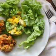 two crab cakes on plate with mango avocado salad