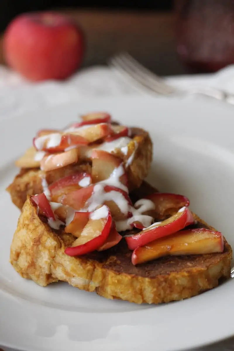slices of pumpkin French toast topped with caramelized apples and a yogurt drizzle