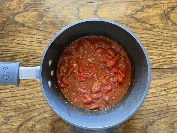 canned tomatoes with spices in pan