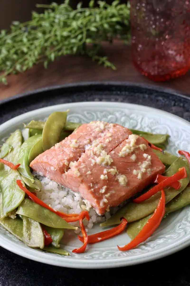 plat with baked salmon, roasted red peppers and snow peas.