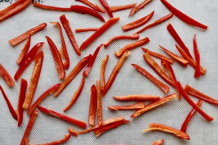 slices of red peppers on baking sheet